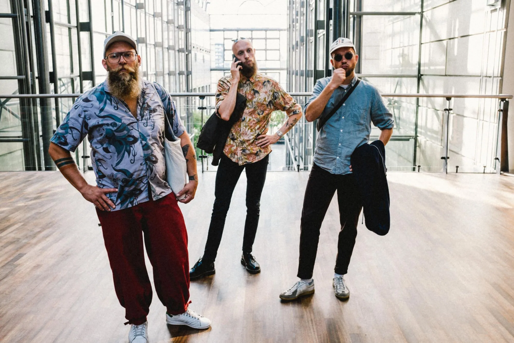 The three members of SVIN standing in a bright glass atrium